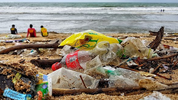 Bali's iconic surf beach in Kuta littered with Coke bottles, thongs, crumpled plastic water cups and drinking straws.