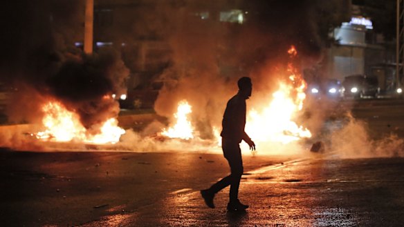 A masked protester runs past garbage set on fire by supporters of the pro-Kurdish Peoples's Democratic Party (HDP) in Diyarbakir, in Turkey's predominantly Kurdish southeast, on Sunday. 