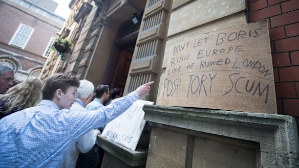 Protest signs are displayed as people queue to listen to Conservative MP Boris Johnson in Bristol on Saturday. 