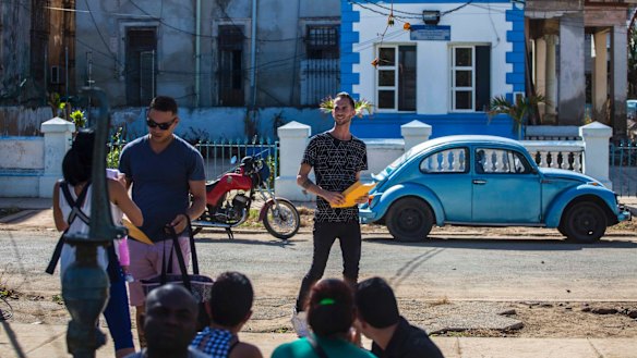 Enmanuel Carrasco, centre, smiles holding his newly issued US visa in Havana on Monday. The US has now suspended visa processing in Havana. 