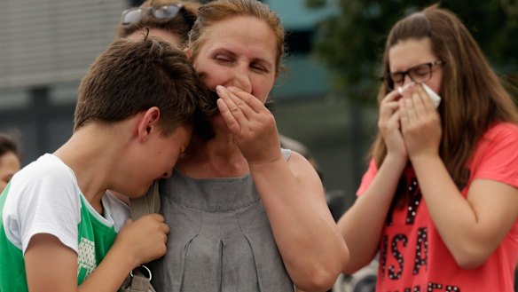 People mourn near the crime scene. 