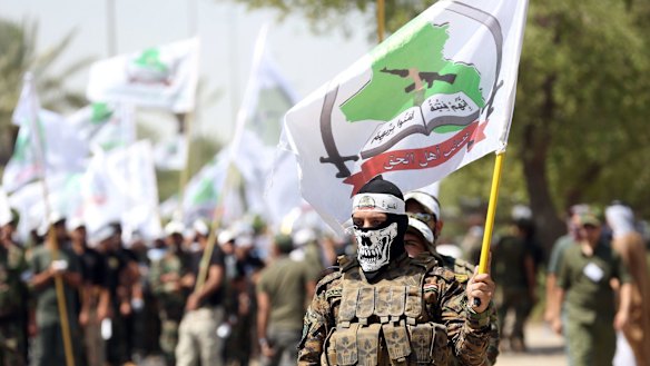 Members of the Shiite group Asaib Ahl al-Haq march in Baghdad in July.