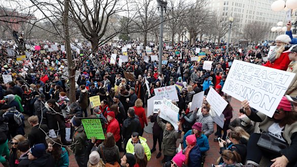Protesters carry signs and chant in Lafayette Park near the White House during a demonstration to denounce President Donald Trump.
