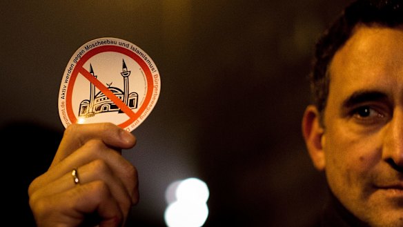 A demonstrator holds a sticker with a crossed mosque symbol during a march against "Islamification" in Berlin.