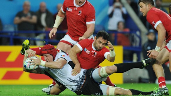 Romania's captain Mihai Macovei scores a try during match against Canada.