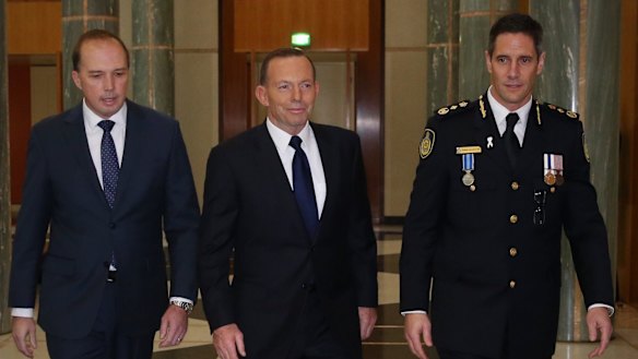 Prime Minister Tony Abbott and Immigration Minister Peter Dutton, left, at the swearing in ceremony of the inaugural Border Force Commissioner Roman Quaedvlieg, right.