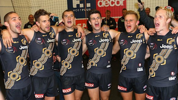 Richmond players sing the club song in the rooms after defeating Essendon in the Dreamtime at the G game on Saturday.