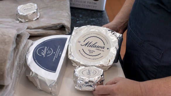 Ceridwen Brown packs cheese for delivery via Australia Post at Milawa in regional Victoria.