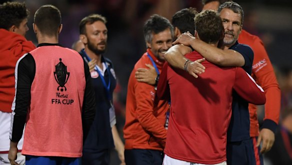 Off to the final: Adelaide coach Marco Kurz (right) celebrates with his players after victory over the Wanderers.