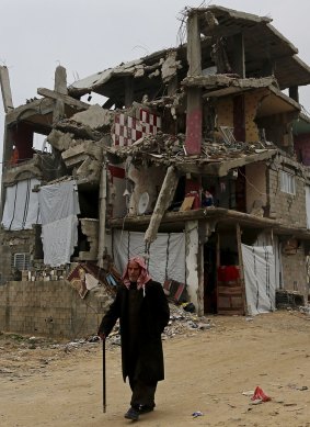 An elderly Palestinian in the Shujaiya district of Gaza City walks past a building destroyed during the conflict between Israel and Hamas in July and August of 2014.