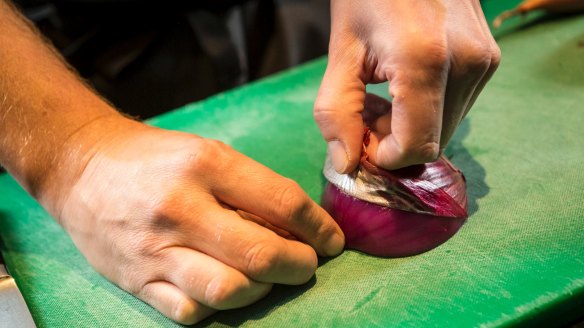 Step 1: With the root facing up, cut onion in half from the root down to the top. Place the flat side onto a cutting board. Peel the onion, pulling the skin back from tip towards root.