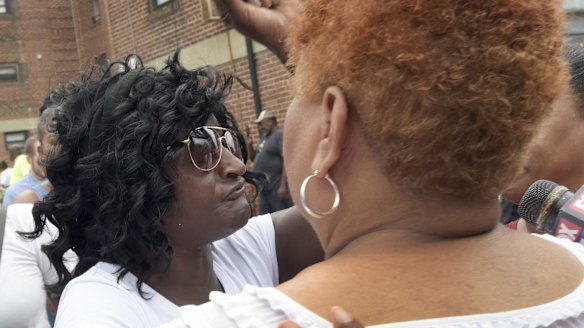 Freddie Gray's mother Gloria Darden, left, raises a fist at a news conference held by Baltimore State's Attorney Marilyn Mosby on Wednesday.