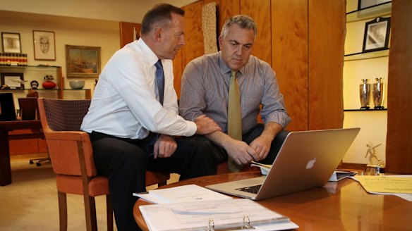 Prime Minister Tony Abbott poses with the Treasurer Joe Hockey as they look through Budget papers in Canberra on Tuesday.