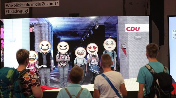 Visitors take part in an interactive emoji display inside the Christian Democratic Union walk-in election manifesto, inside a former department store in Berlin, Germany.