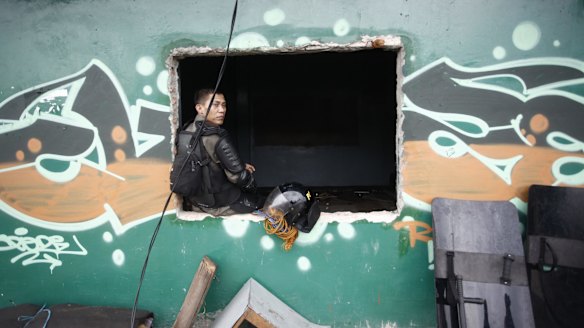 A security officer sits on the window of a cafe before its demotion.