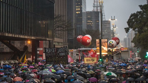 Protesters gather in the rain on Avenida Paulista, Sao Paulo, on Sunday.  