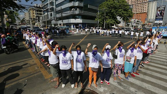 Anti-Duterte protesters link arms to block traffic in Quezon city, northeast of Manila, on Thursday.