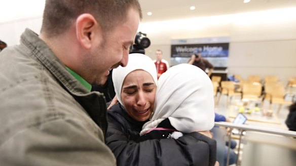 Hisham, left, and Mariam Yasin, centre, welcome their mother Najah al-Shamieh, from Syria, after immigration authorities released her at Dallas-Fort Worth Airport on Saturday.
