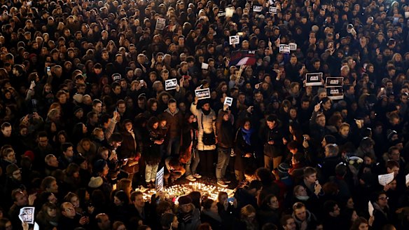 People hold a vigil at the Place de la Republique for victims of of the terrorist attack