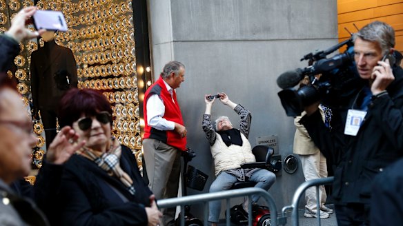 Pedestrians stop to take pictures or just look at Trump Tower in New York.