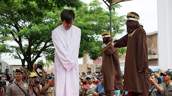 The masked men took turns to deliver the lashes  - 83 in the end - with a cane according to Aceh's sharia-inspired laws.