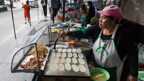 A vendor cooks crepes on a hotplate at a food stall in Phaya Thai, Bangkok.