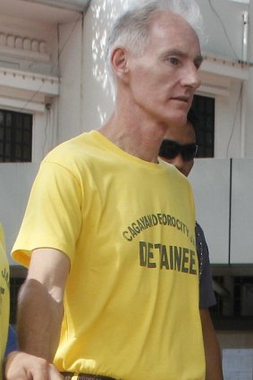 Scully in handcuffs as he arrives at Cagayan de Oro city hall on Tuesday.