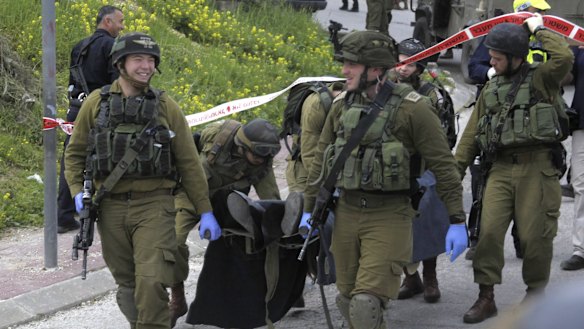 Israeli soldiers carry the body of one of two Palestinian who were killed after a stabbing attack in Hebron, on the occupied West Bank on Thursday. 