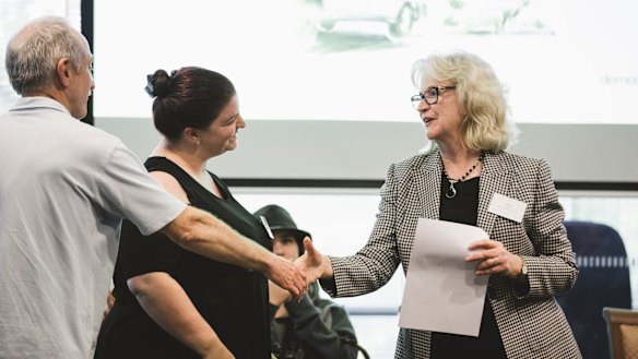 Citizen jurors Darryl Massey and Emma Rowland present the jury's final report to the head of the ACT Public Service, Kathy Leigh.
