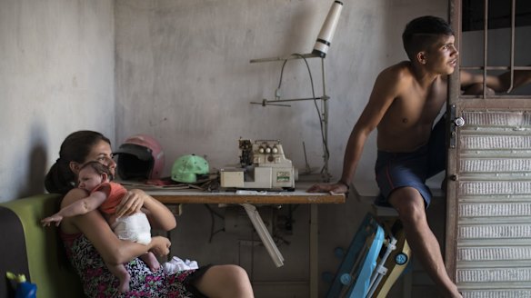 Angelica Pereira, left, holds her daughter Luiza near her husband Dejailson Arruda at their home in Santa Cruz do Capibaribe, Pernambuco, Brazil. Luiza was born in October with the rare condition microcephaly.