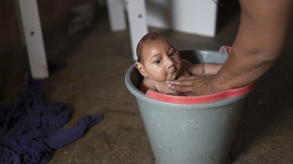 Solange Ferreira bathes her son Jose Wesley in a bucket at their house in Poco Fundo, Pernambuco, Brazil. Ferreira says her son enjoys being in the water, she places him in the bucket several times a day to calm him.
