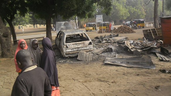 Children stand near the scene of a suicide bomb attack in Potiskum.