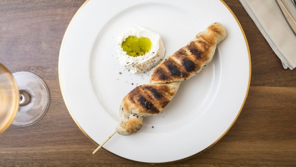 Stockbrot (bread on a stick) served with creme fraiche and pumpkin seed oil.