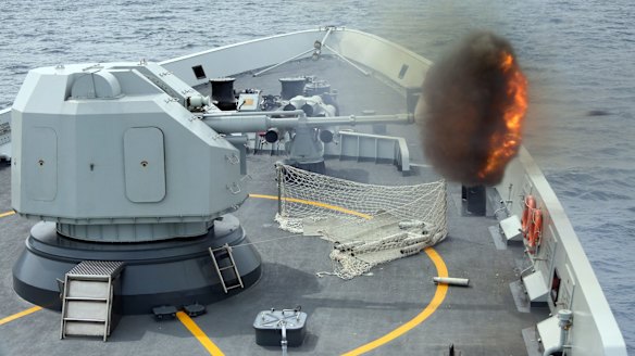 An anti-surface gunnery is fired from a Chinese missile frigate during military exercises by Singapore and Chinese navies in the South China Sea. 