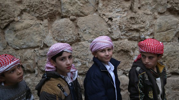 Yazidi boys wait to kiss the entrance of the Temple of Lalish, the holiest site of the Yazidi religion, last week in the Nineveh Province village of Lalish, Iraq. 