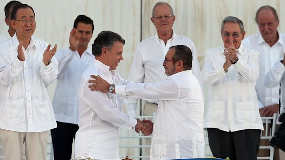 Colombian President Juan Manuel Santos, front left, and the top FARC Timochenko, shake hands after signing the peace agreement. Behind, from left, are UN's Ban Ki-moon, Mexican President Enrique Pena Nieto, Peruvian President Pedro Pablo Kuczynski, Cuban President Raul Castro, and Spain's former King Juan Carlos.