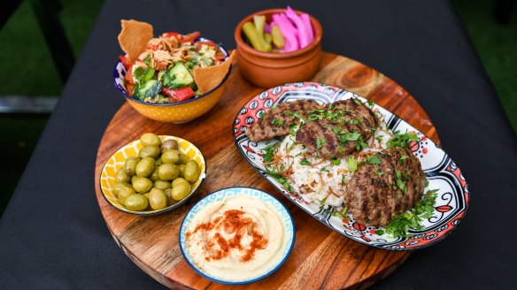 Shish kofta platter with fattoush, pickles and hummus.