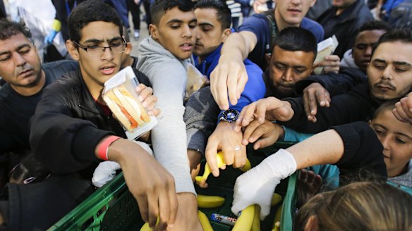 Migrants grab for food at a reception centre for refugees and asylum seekers in Berlin.