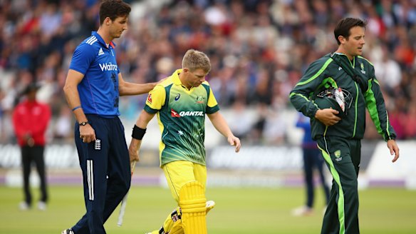 David Warner leaves the ground after sustaining an injury.