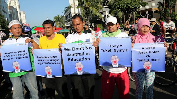 Indonesians hold posters aimed at Tony Abbott during protests in Jakarta.