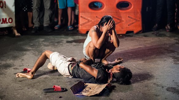 Jennilyn Olayres weeps over the body of her husband Michael Siaron after armed assailants in a motorcycle shot him in a main thoroughfare in Manila in July.