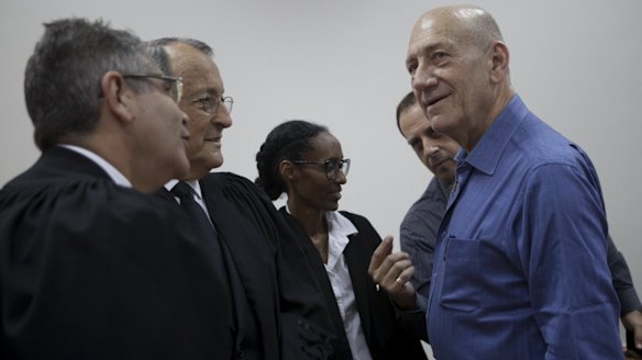 Ehud Olmert with his lawyers on Monday.