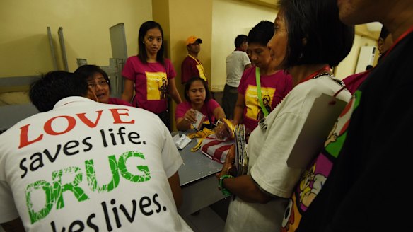 Solidad Pangilinan, second right, signs up with her partner Manuel Tanjutco for drug rehabilitation after surrendering. 