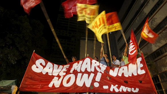 Activists wave flags after it was announced that Veloso's execution had been stayed. 