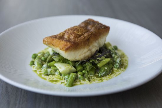 Coral trout is served crisp-skinned atop peas and asparagus.