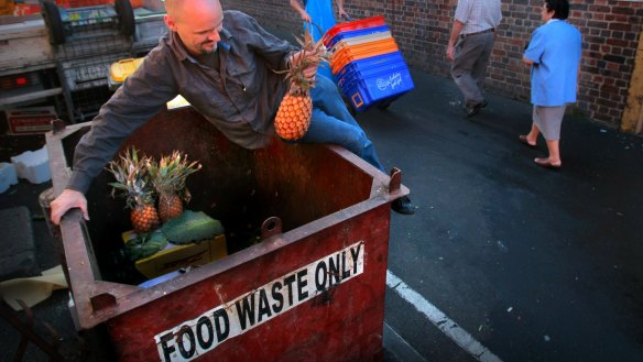 A skip diver hunts for food waste at Melbourne's Queen Victoria Market.