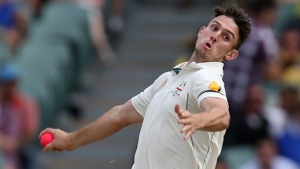 Pinkish hue: Mitchell Marsh bowls sends one down during the first day-night Test.