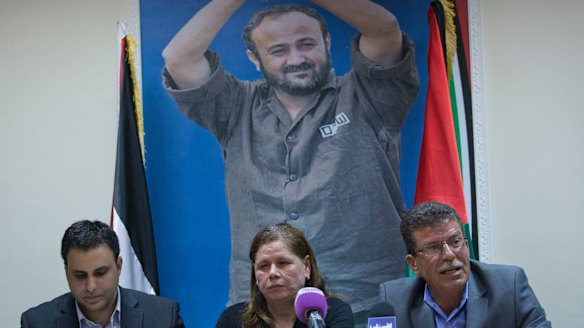 Fadwa Barghouti, centre, in front of a picture of her husband during the third week of the hunger strike with Qaddoura Fares, right, who heads an advocacy group for Palestinian prisoners.