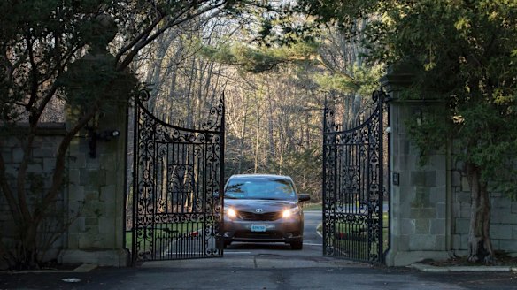 Cars with diplomatic plates drive out of a compound near Glen Cove on Long Island on Friday after the US expelled dozens of Russian diplomats.