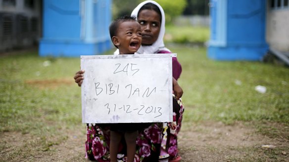A Rohingya woman and her child pose for identification photographs in a temporary compound for refugees in Indonesia's Aceh Province in May.